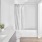 Bright, modern bathroom with white subway tile, patterned shower curtain, and minimalist vanity.