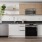 A kitchen with stainless steel appliances, white cabinets, wood accents, and abstract art.