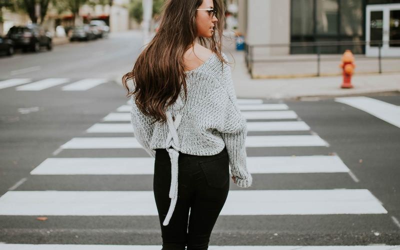 Close to the center of everything a person walking in a crosswalk